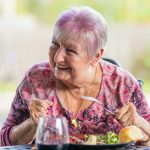 woman in purple and pink floral long sleeve shirt sitting on chair
